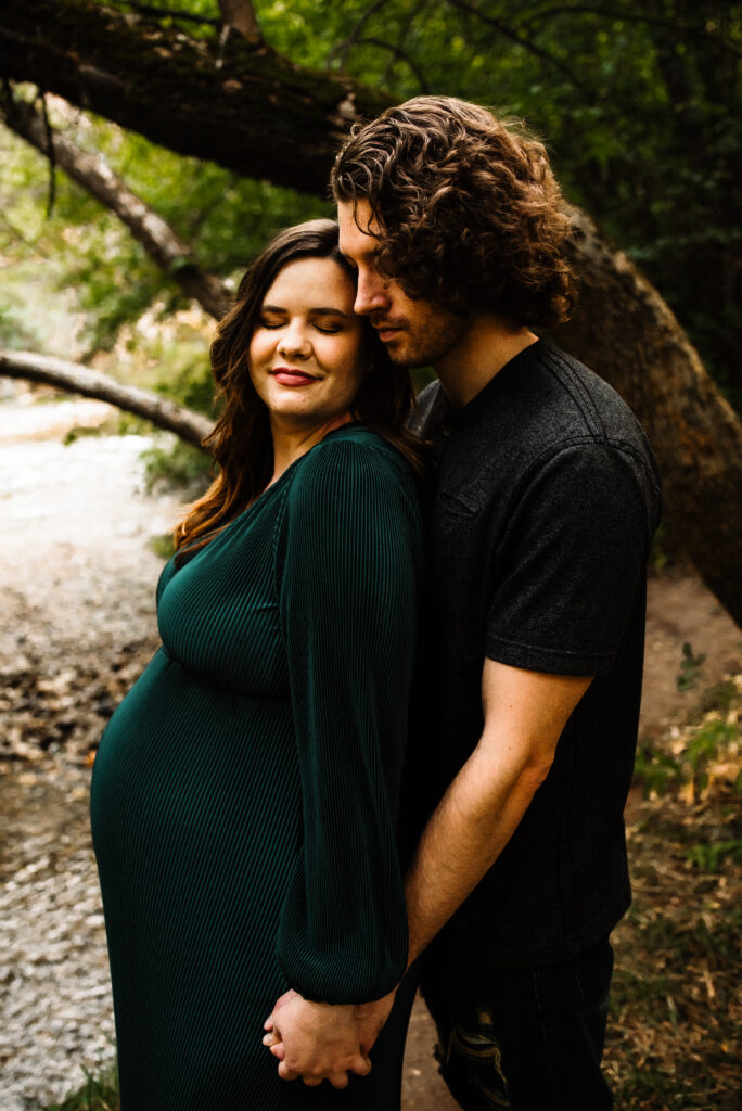 Summer Utah maternity session wearing dark green dress