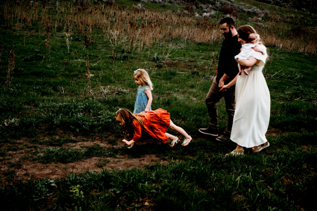Utah family photography with little girls crawling through grass